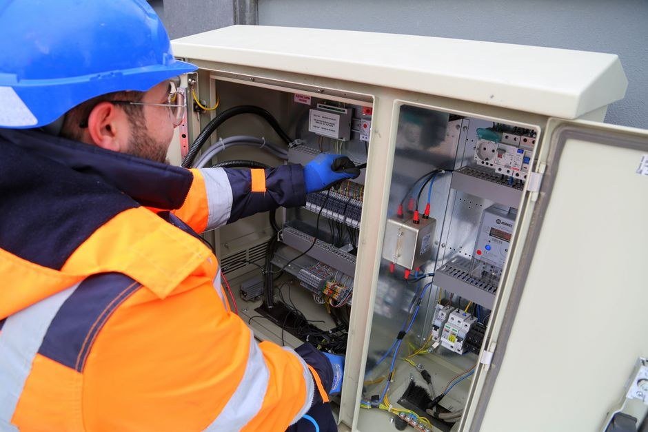 Electrician installing a breaker module in a control panel